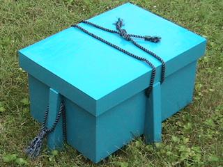 A blue wooden chest with four legs.