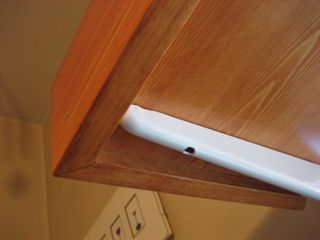 The underside of one corner,
showing the mitered joinery,
the underside lip,
and the shelf bracket..