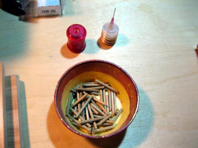 A bowl full of pegs, plus glue and sharpener.